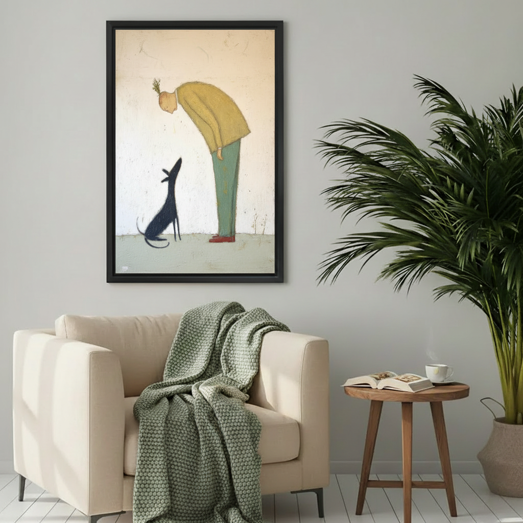 Man in yellow sweater and black dog eye contact tender minimalist wall art print in black frame beside cream armchair with green knit throw and round wood side table in Scandinavian living room