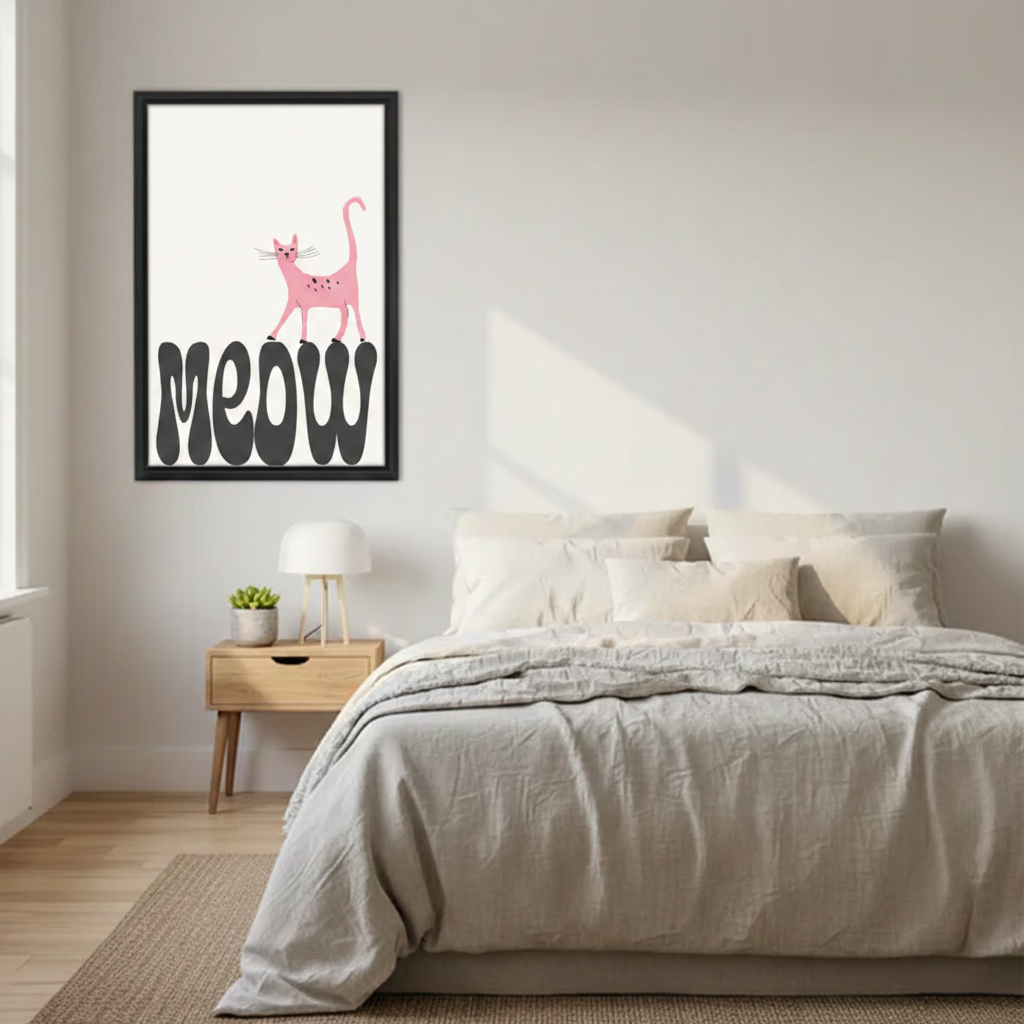 Minimalist pink cat meow wall art print in black frame above Scandinavian bed with linen bedding and oak nightstand with white lamp in modern bedroom