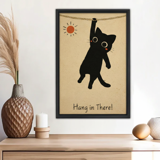 Funny hang in there black cat hanging on rope vintage motivational wall art print in black frame above wooden sideboard with pampas grass vase and white candle in boho entryway