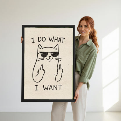 Woman holding large framed funny cat I do what I want sunglasses middle finger humorous wall art print in black frame showing actual print size in bright minimalist white studio
