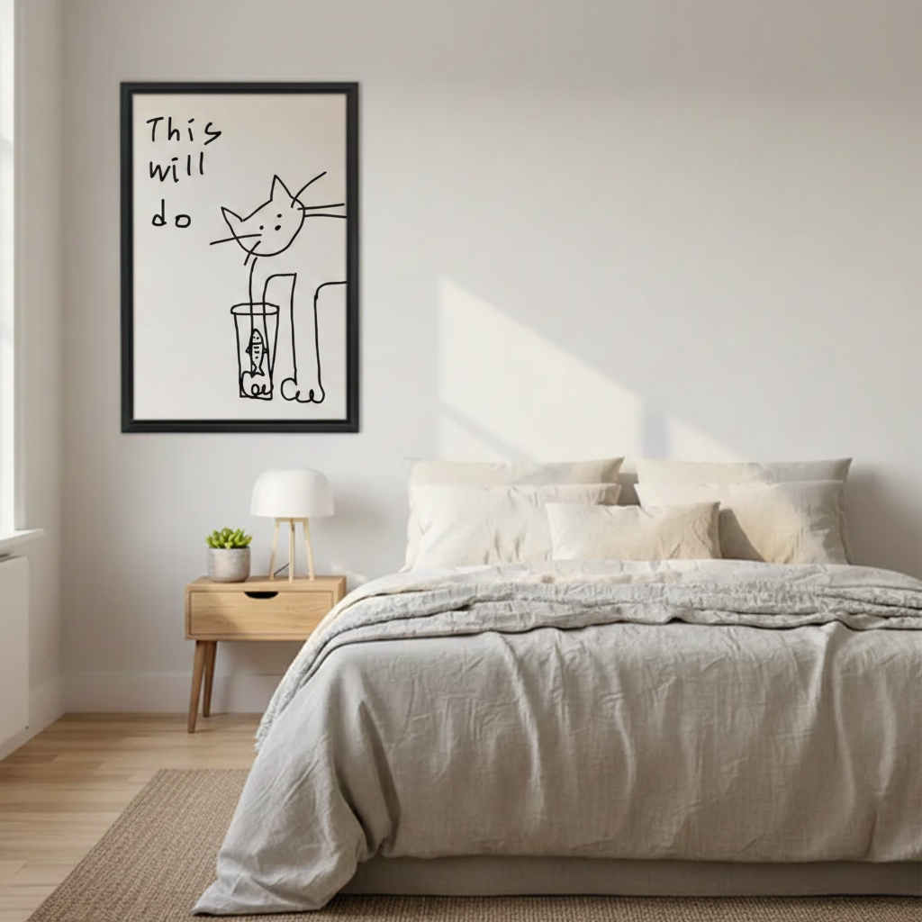 Minimalist this will do cat and fish glass line drawing wall art print in black frame above Scandinavian bed with linen bedding and oak nightstand in modern bedroom