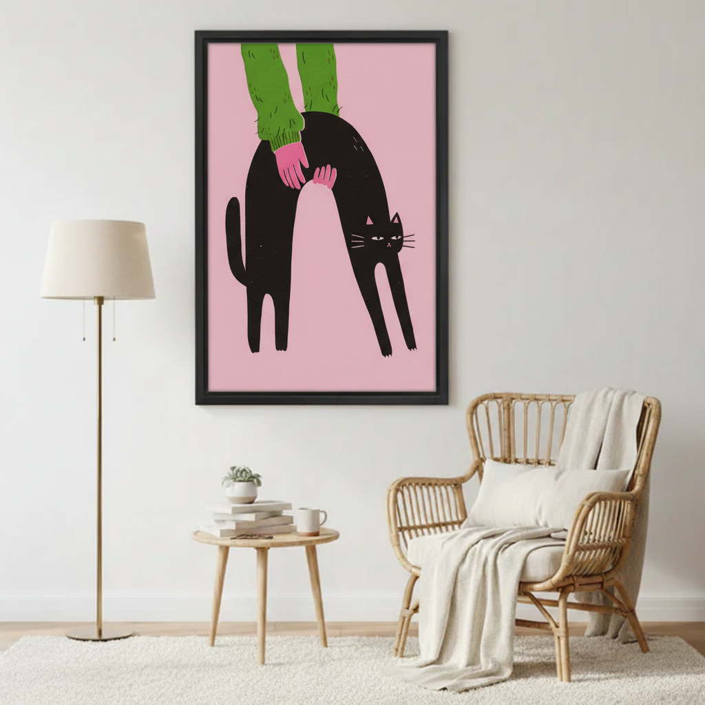 Bold black cat arching back green sweater hand pink background wall art print in black frame beside rattan armchair with cream throw and gold floor lamp in cozy living room