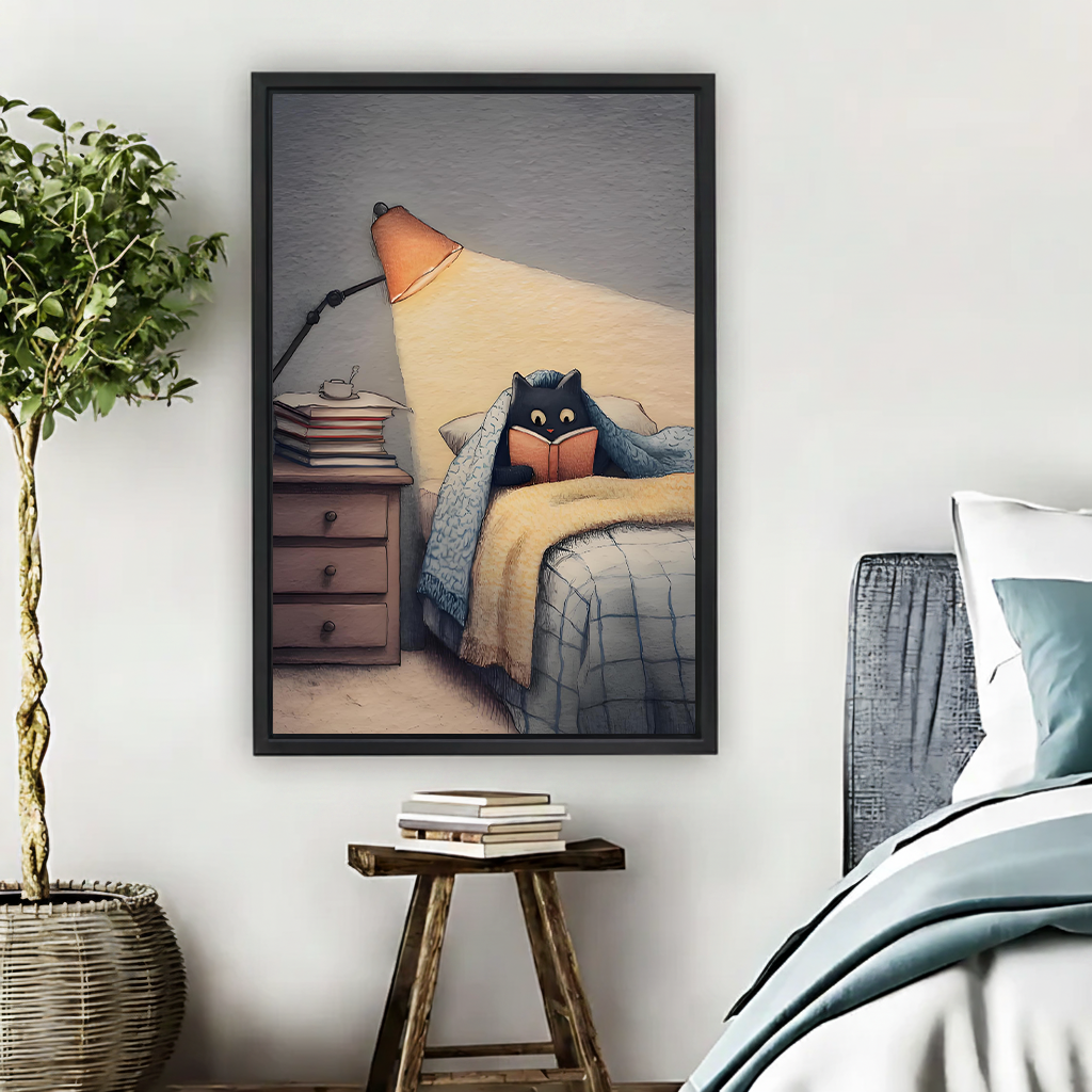 Black cat reading in bed under blanket by warm orange lamp cozy pencil illustration framed wall art hung on white wall above wooden stool with stacked books in Scandinavian bedroom

