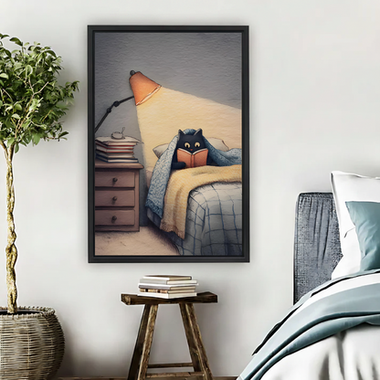 Black cat reading in bed under blanket by warm orange lamp cozy pencil illustration framed wall art hung on white wall above wooden stool with stacked books in Scandinavian bedroom

