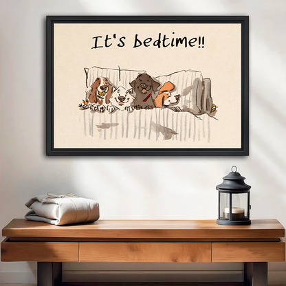 Four dogs snuggled in bed with It's Bedtime quote funny whimsical framed canvas wall art in black frame displayed above wooden console table with lantern