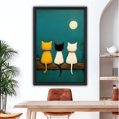 Three cats watching moon teal night sky framed canvas wall art above dining table