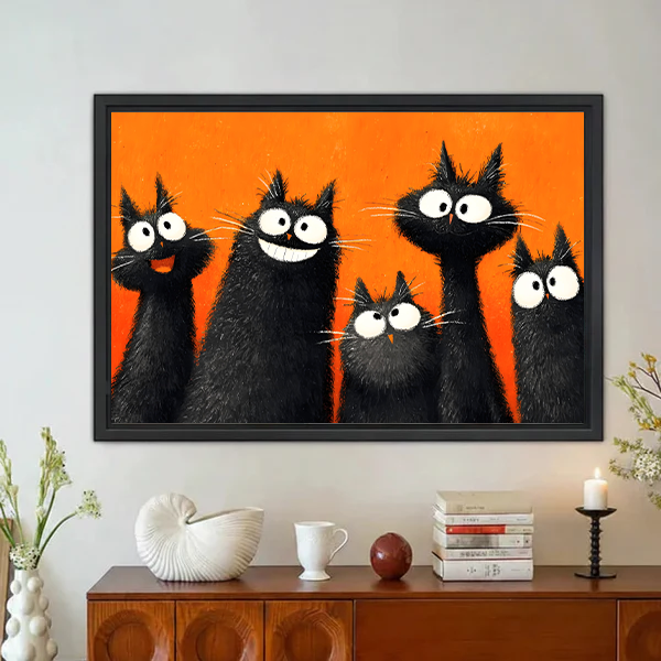 Five fluffy black cats with big white eyes and wild expressions on bold orange background pop art oil painting style framed wall art hung on grey wall above vintage walnut sideboard with white ceramic shell sculpture mug brown ball stacked books and black candle holder