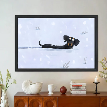 Snow Day dachshund whimsical framed wall art with cartoon wiener dog in snow displayed above wooden sideboard