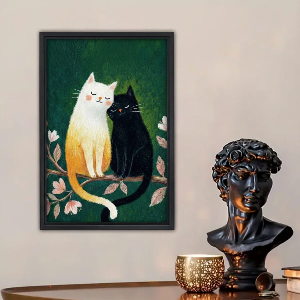 Whimsical cat couple framed canvas wall art — black framed print of two cats on a cherry blossom branch, displayed on a beige wall