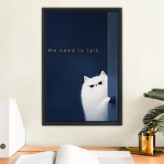 Funny white cat "We need to talk" framed wall art in black frame above wooden office desk