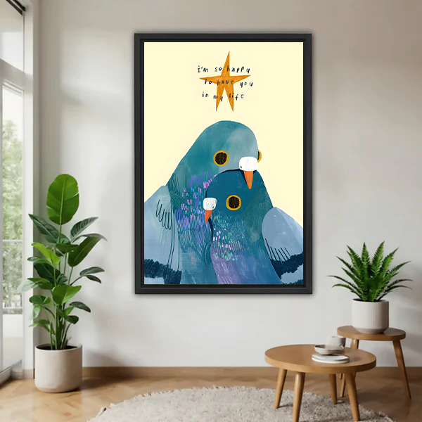 Two love birds snuggling whimsical framed canvas wall art with I'm so happy to have you quote in black frame displayed in bright living room with tropical plants