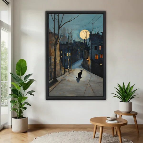 Framed black cat moonlit street watercolor wall art print in a bright living room with indoor plants, atmospheric night scene decor