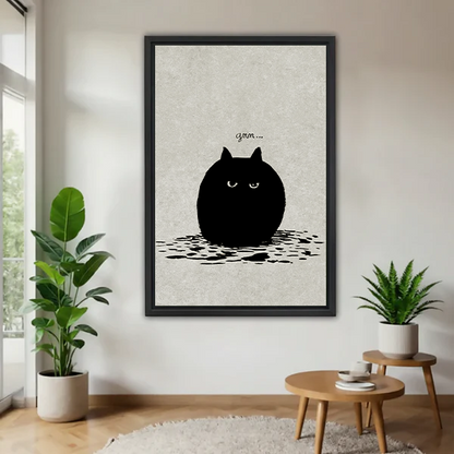 Grumpy round black cat minimalist funny framed canvas wall art in black frame displayed in bright living room with tropical plants and wooden side table