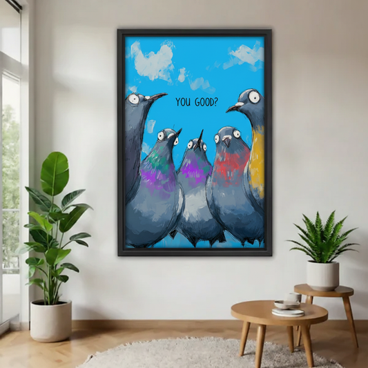 Funny pigeons "You Good?" framed wall art print, black frame, colorful whimsical bird illustration on bright blue sky, displayed in a bright minimalist living room with indoor plants and round side table