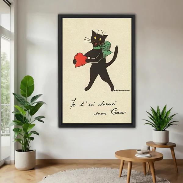 Framed French vintage black cat holding a red heart wall art print in a bright living room with indoor plants, romantic illustrated decor