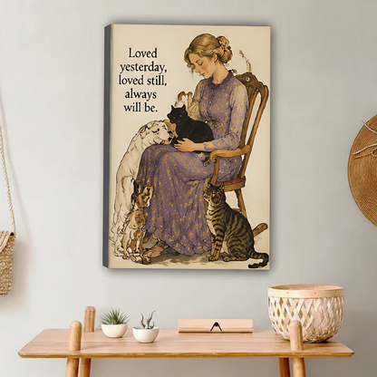 Woman in lavender floral dress sitting on wooden chair holding black cat with white long-haired dog beagle and tabby cat beside her vintage watercolor illustration with loved yesterday loved still always will be quote gallery wrap canvas art displayed on white wall above wooden desk with succulent white bowl and wicker basket