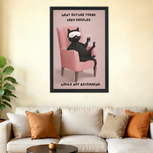 Whimsical black cat went outside very peopley would not recommend wall art print in black frame above cream sofa with orange cushions in warm modern living room