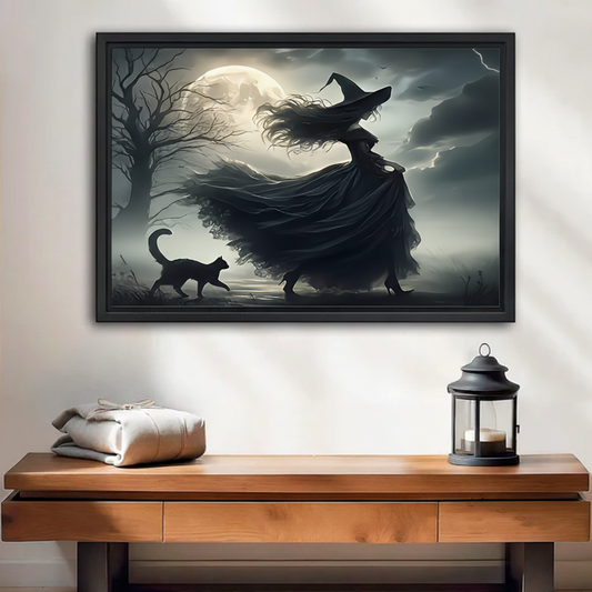 Witch and black cat moonlit night framed wall art print, black frame, dark gothic oil painting style, displayed above a rustic wooden console table with lantern decor in a moody neutral entryway