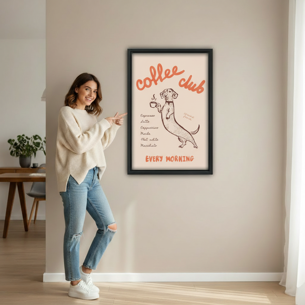Woman pointing at dachshund coffee club every morning retro poster wall art print in black frame showing actual print size on beige wall in bright minimalist entryway