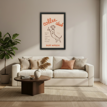 Funny dachshund coffee club every morning vintage poster wall art print in black frame above cream sofa with dark round coffee table pampas grass vase and fiddle leaf fig in modern living room