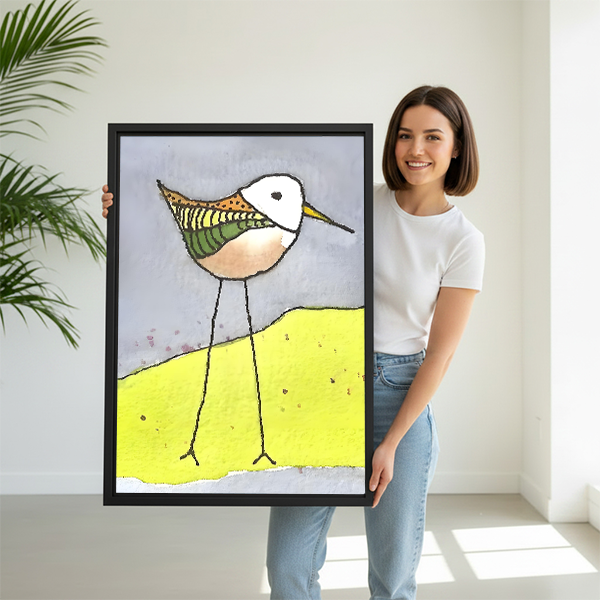 Woman holding quirky illustrated sandpiper yellow dune framed canvas wall art, large size colorful bird print for home decor