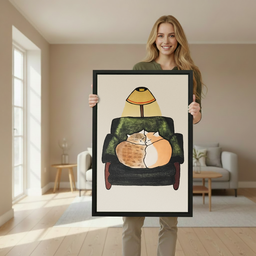 Woman holding large framed canvas print of two cats snuggling in armchair cozy whimsical illustration wall art