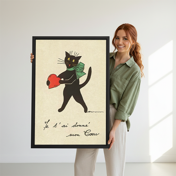 Woman holding a large framed French vintage black cat heart art print, romantic illustrated wall art perfect as a Valentine's Day gift
