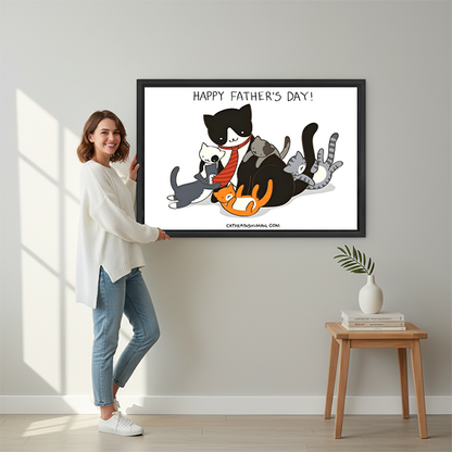 Woman in white sweater holding large Happy Father's Day funny cat family framed canvas print with cartoon dad cat and kittens beside wooden stool with vase