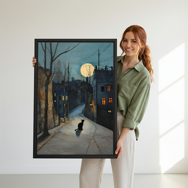 Woman holding a large framed black cat moonlit street art print, atmospheric watercolor wall art perfect as a unique home gift