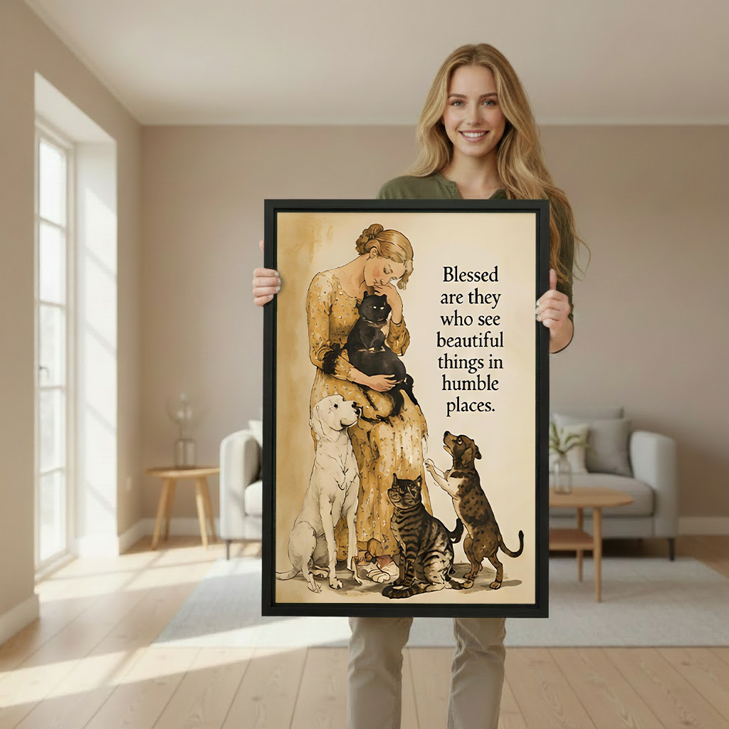 Smiling blonde woman in olive green sweater holding large blessed beautiful things humble places woman cats dogs vintage watercolor framed canvas print with black cat white labrador tabby cat and dachshund in bright beige living room with white sofa and wooden side table