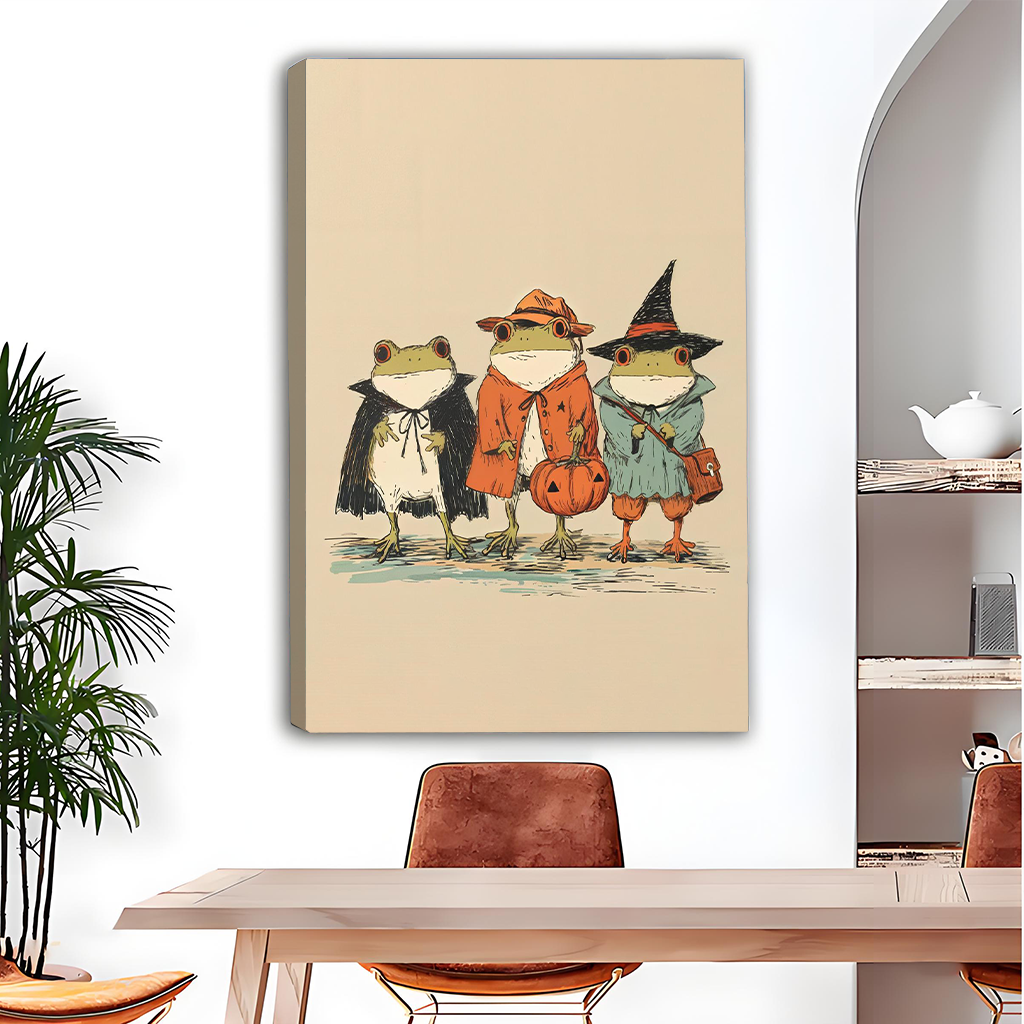 Framed whimsical Halloween frogs canvas wall art with a pumpkin bucket above a wooden dining table.