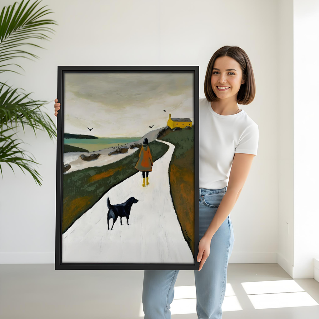 Woman holding large Nordic coastal walk woman dog framed canvas print, black frame, size reference lifestyle photo, moody landscape wall art