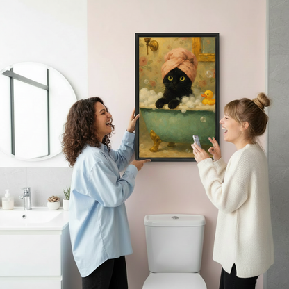 Two women laughing while hanging funny black cat in bathtub framed wall art print, black frame, vintage floral oil painting style with rubber duck, showing easy installation in a bright modern bathroom