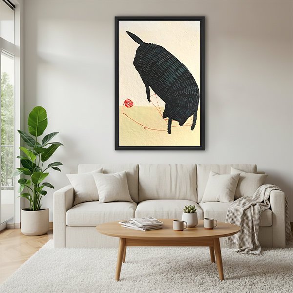 Zen black cat playing with red yarn framed wall art in black frame above cream sofa with round coffee table in modern living room