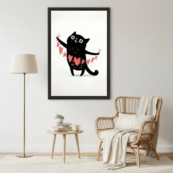 Whimsical black cat holding pink heart garland framed canvas print in bright Scandinavian living room with rattan chair
