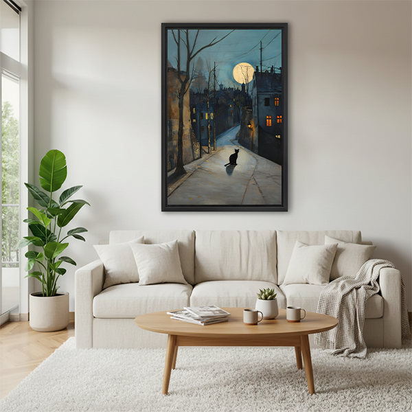 Black cat moonlit street framed watercolor print above a cream sofa in a Scandinavian living room, moody night scene wall art