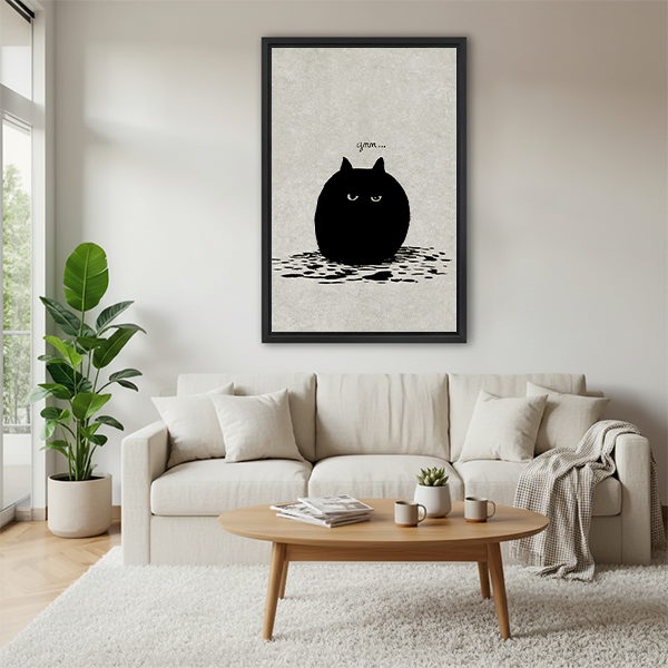 Grumpy black cat minimalist funny framed canvas wall art above cream sofa in bright Scandinavian living room with round coffee table and throw blanket