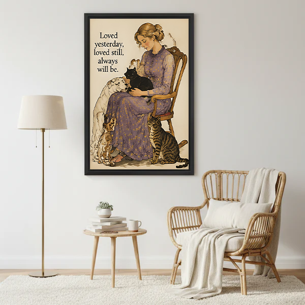 Woman in lavender floral dress sitting on wooden chair holding black cat with white long-haired dog beagle and tabby cat beside her vintage watercolor illustration with loved yesterday loved still always will be quote framed wall art hung on white wall beside rattan armchair with white throw blanket round side table succulent mug and gold floor lamp