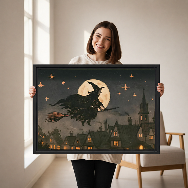 Vintage moonlit witch canvas wall art in a black frame above a cream sofa, featuring stars and glowing rooftops.