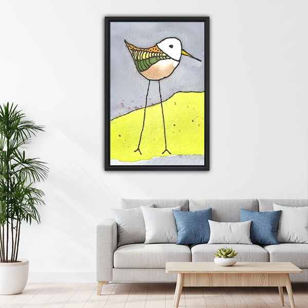 Illustrated sandpiper on yellow dune framed canvas wall art above sofa, quirky colorful bird print for modern living room decor