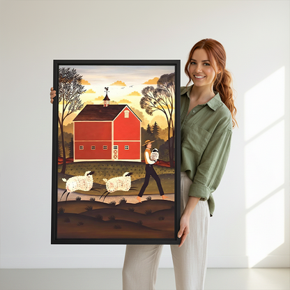 Red barn and sheep canvas wall art in a black frame beside a bed with woven headboard.