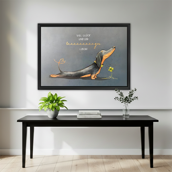 Humorous dachshund art print in black frame above minimalist black console table