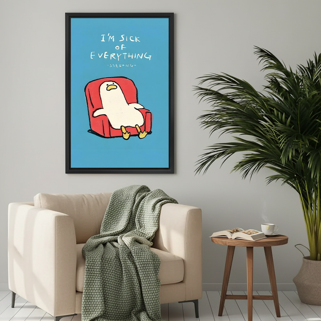 White cartoon duck slouched in red armchair with I'm sick of everything handwritten text on blue background funny minimalist illustration framed wall art hung on light grey wall above cream armchair with sage green knit throw wooden round side table open book coffee cup and large palm plant