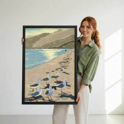 Woman holding large black framed vintage seagulls beach wall art — coastal canvas print for home decor