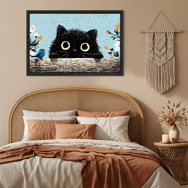Fluffy black cat peeking vintage floral framed canvas art with yellow eyes and blue bird hung on terracotta wall above rattan bed with macrame wall hanging in boho bedroom