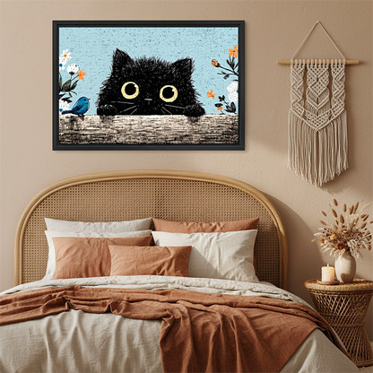 Fluffy black cat peeking vintage floral framed canvas art with yellow eyes and blue bird hung on terracotta wall above rattan bed with macrame wall hanging in boho bedroom