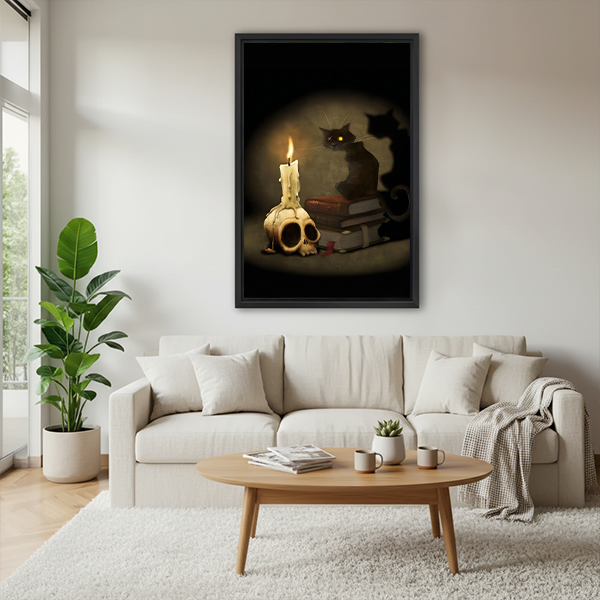 Black-framed gothic black cat canvas wall art showing a skull candle and books above a cream sofa.