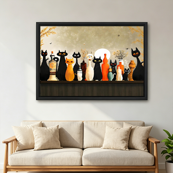 Whimsical moonlit cats canvas wall art in a black frame above a cream sofa, featuring cats and decorative bottles.