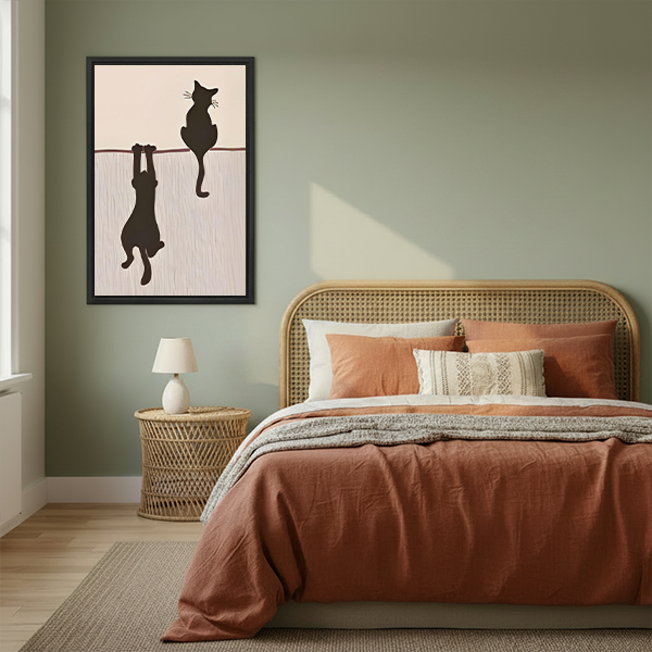 Funny two black cats hanging minimalist framed canvas wall art in boho bedroom with rattan headboard and sage green walls
