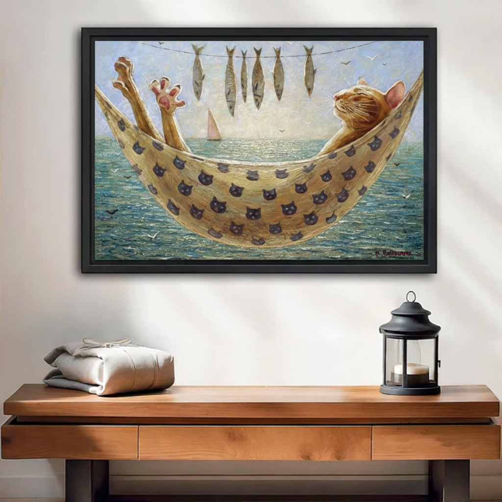 Funny cat hammock canvas wall art in black frame above wooden console, orange tabby lounging over ocean with hanging fish